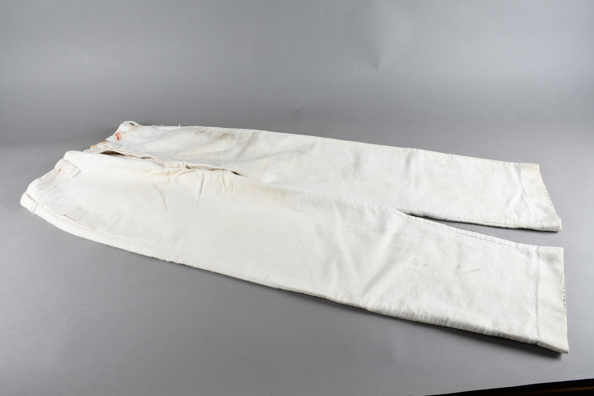 Hvit uniformsbukse med hemper til belte. Høyt liv