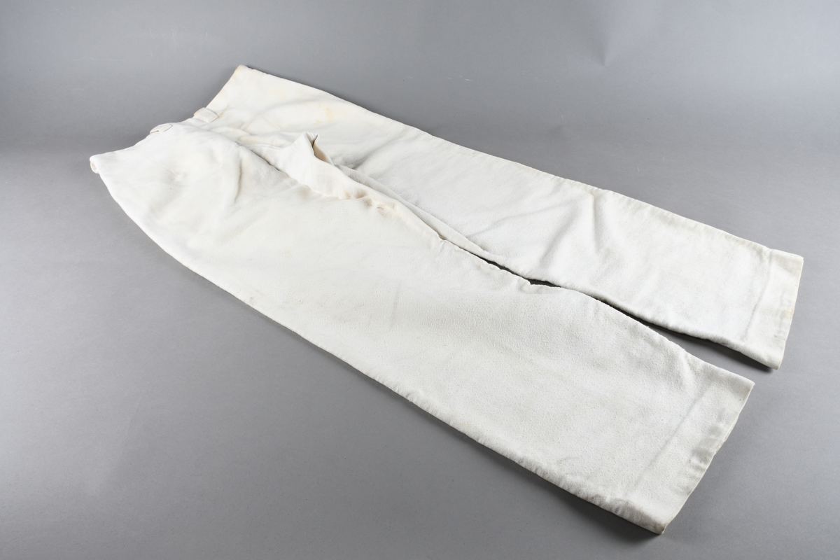 Hvit uniformsbukse med hemper til belte. Høyt liv