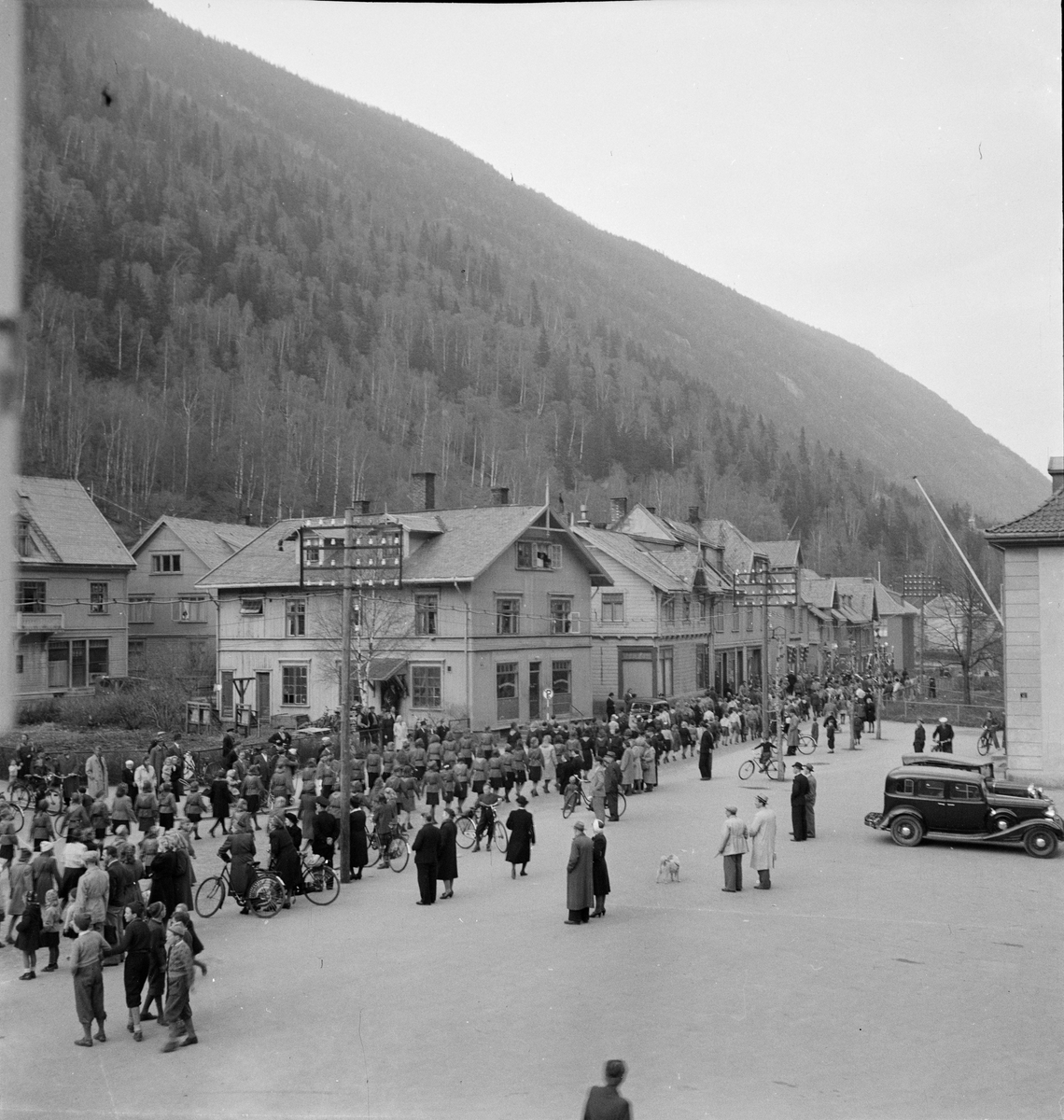 Opptog med speidere ved Rjukan Torg. Butikker østover langs Sam Eydes gate.