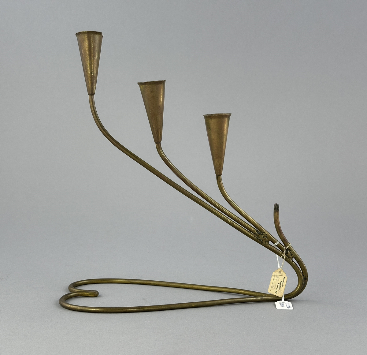 Adventsljusstake av rundjärn med fyra ljuspipor.
