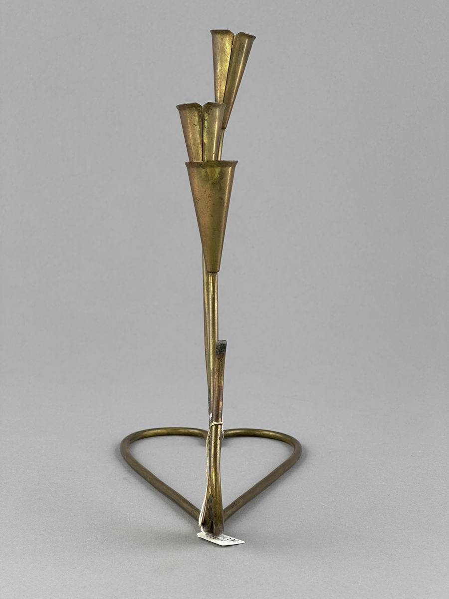 Adventsljusstake av rundjärn med fyra ljuspipor.
