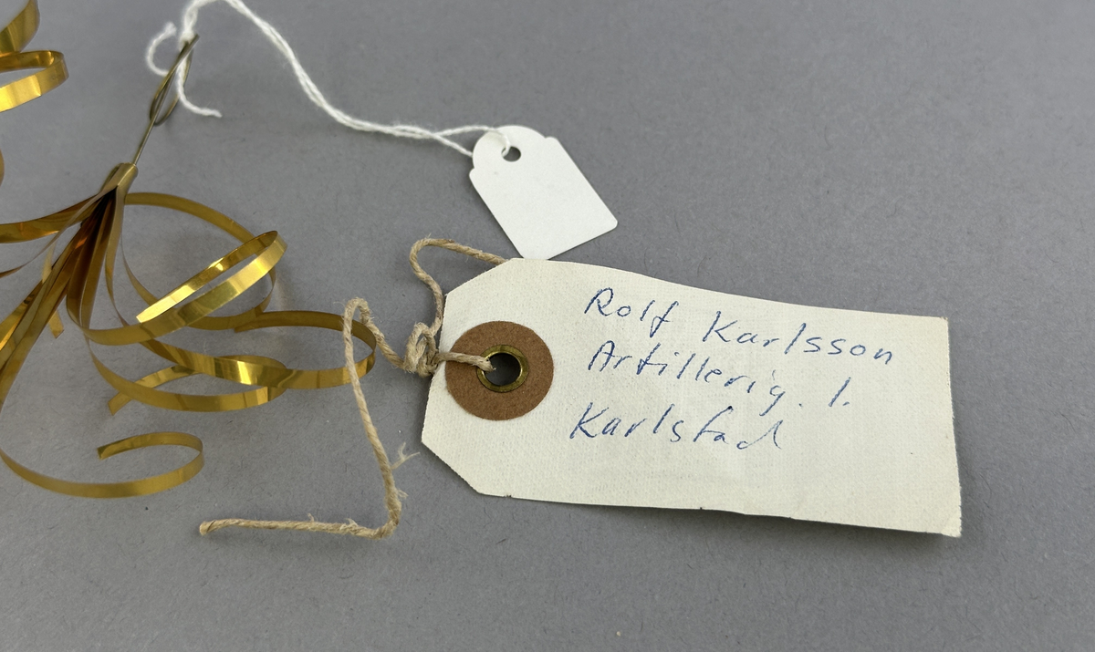 Prydnad av lockade remsor av bladmässing.
