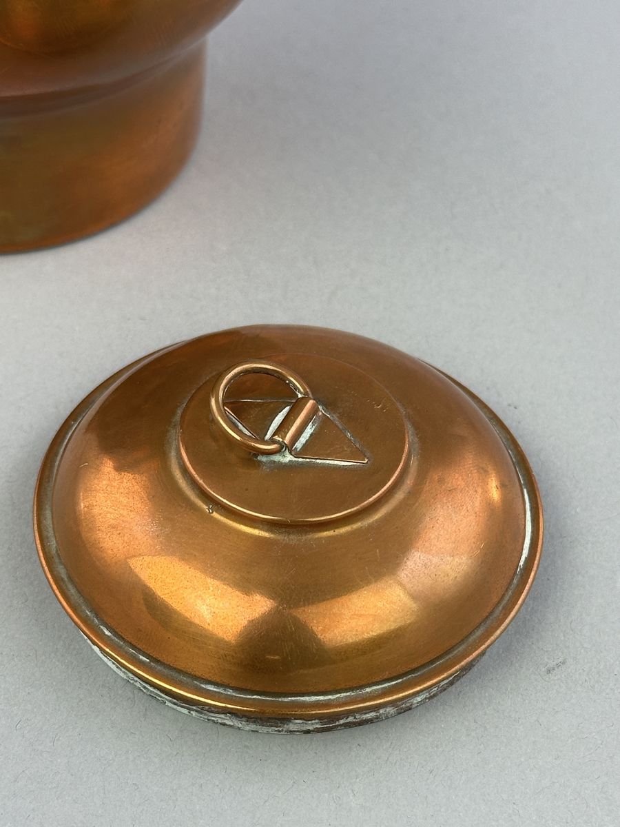 Rund gräddflaska av koppar med lock