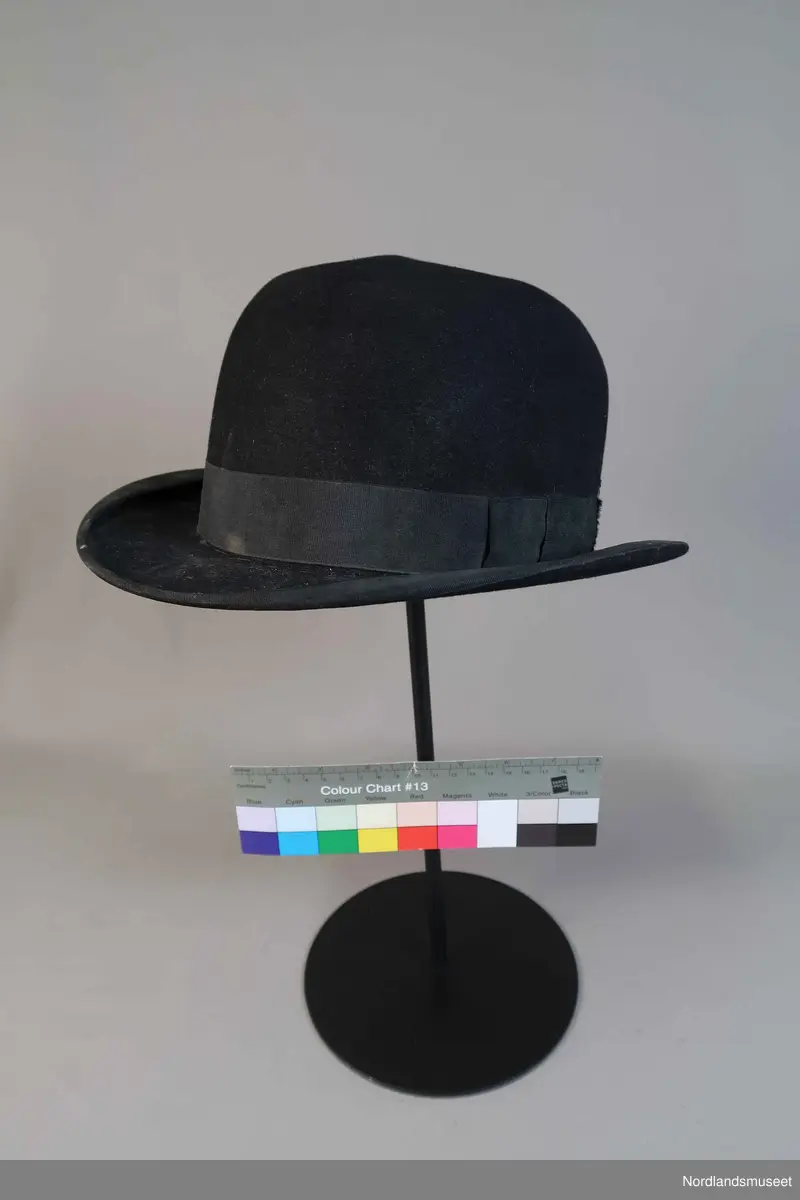 Bowlerhatt, svart filt. Brem kantet med svart silke i ripsbinding. Svettebånd av lys brunt skinn. Lyst silkefor.
