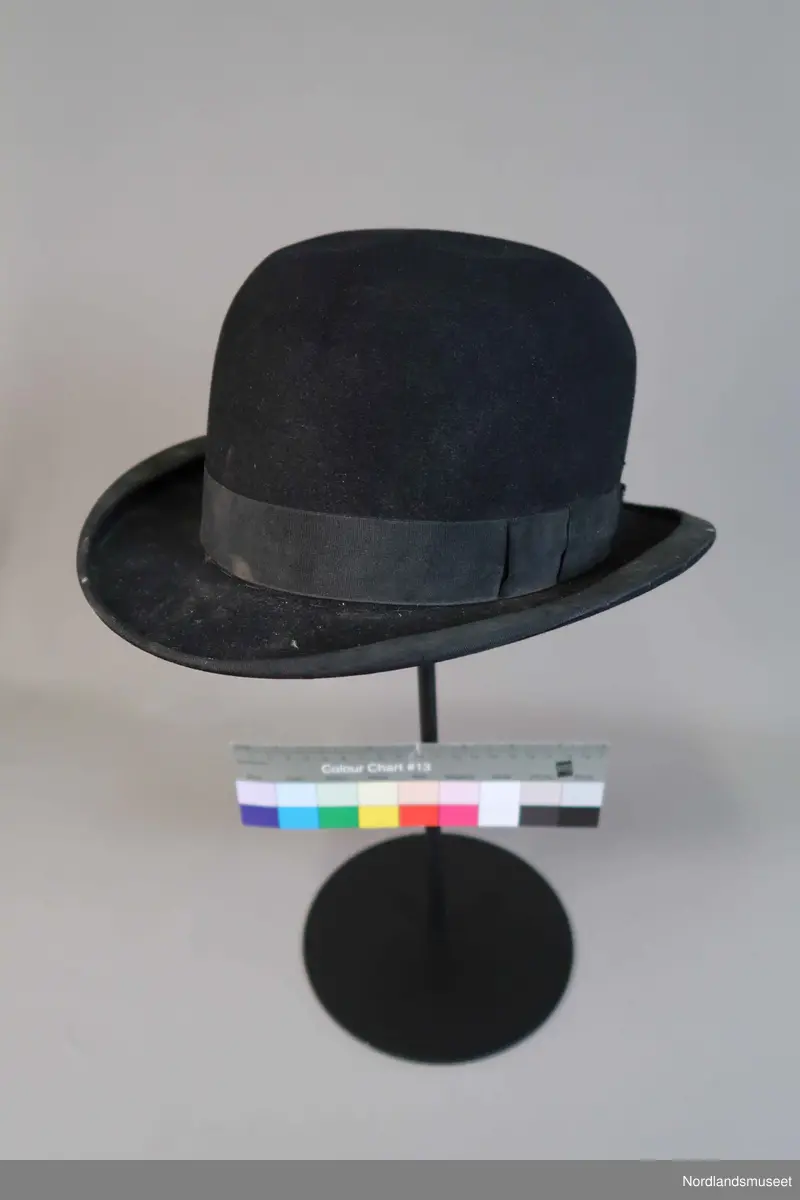 Bowlerhatt, svart filt. Brem kantet med svart silke i ripsbinding. Svettebånd av lys brunt skinn. Lyst silkefor.