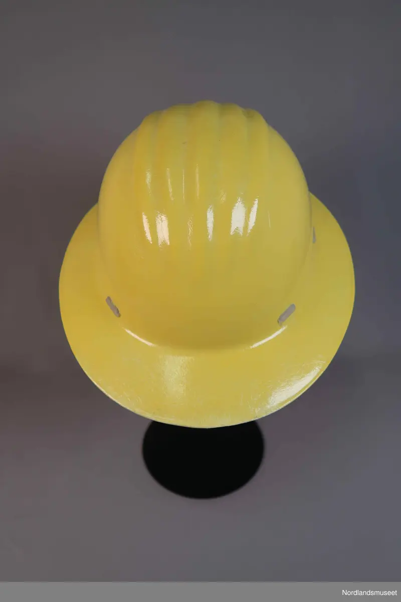 Hjelm i hardplast. Merka med "Industrivern". Feste og reimer i plast på innsiden.