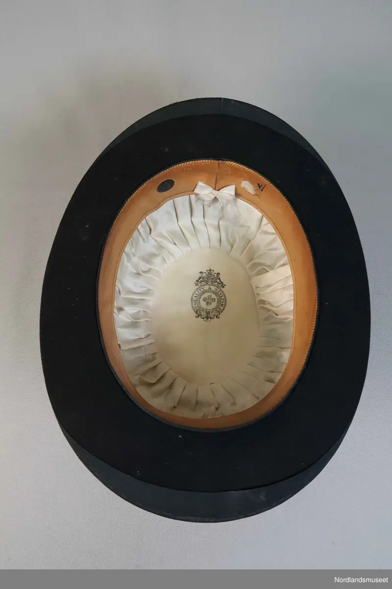 Bowlerhatt, svart filt. Brem kantet med svart silke i ripsbinding. Svettebånd av lys brunt skinn. Lyst silkefor.