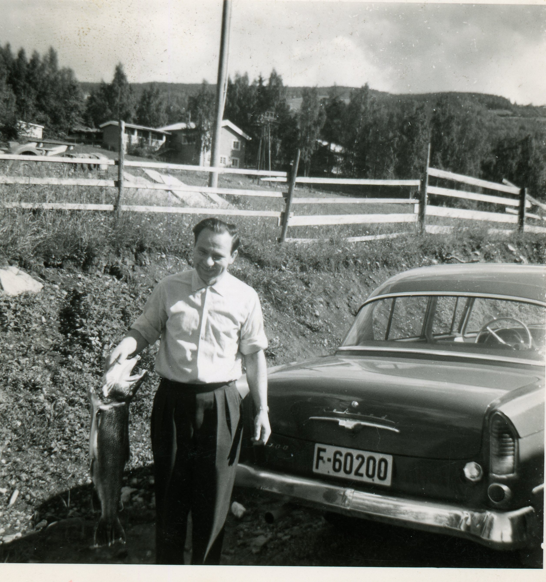 Odd Frøysok har fått stor fisk, står bak Opel Rekord (1958-60) med registreringsnummer F-60200
