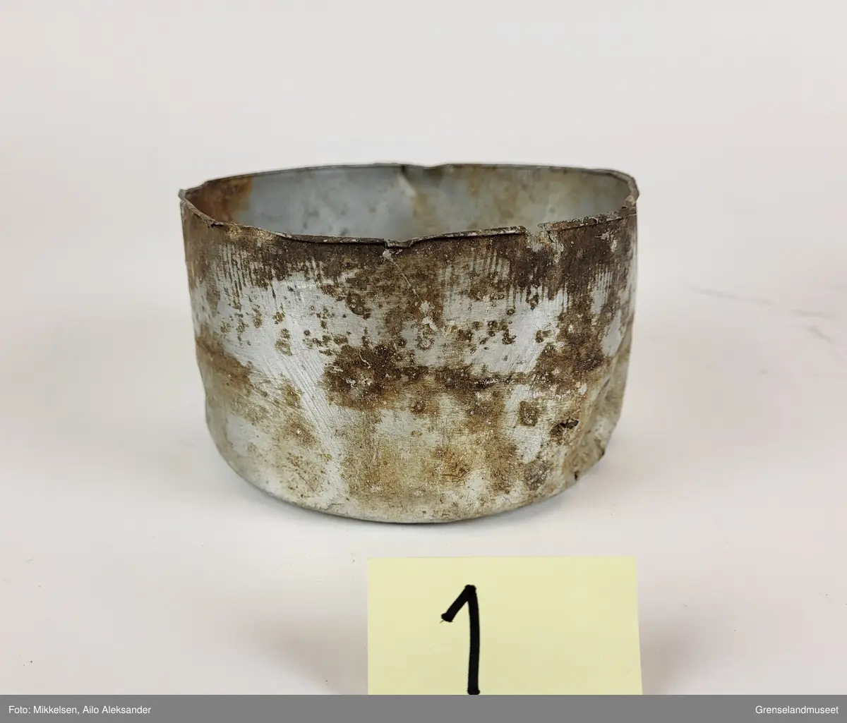 Gjenstanden er en matskål i aluminium som har vært brukt av sovjetiske krigsfanger under andre verdenskrig (1939-1945). Matskålen har ligget ute og fått oksiderings skader som følge av å ha vært eksponert til saltinnholdene sjøluft. Matskålen har fått hull og lekker fra bunnen. Ettersom at gjenstanden har ligget ute har det blitt avfargning fra organiske materialer. Matskålen har navnet til personen som brukte den innrisset på seg.   