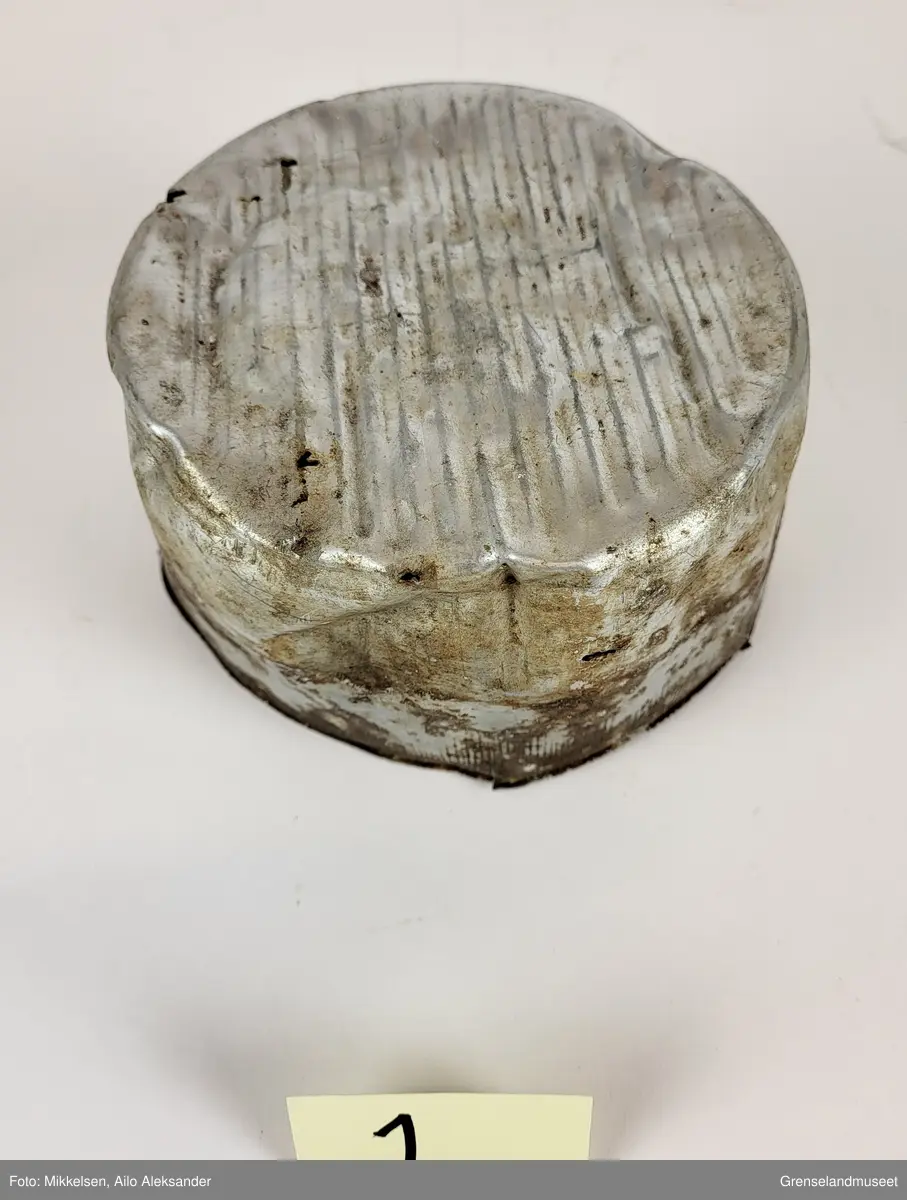 Gjenstanden er en matskål i aluminium som har vært brukt av sovjetiske krigsfanger under andre verdenskrig (1939-1945). Matskålen har ligget ute og fått oksiderings skader som følge av å ha vært eksponert til saltinnholdene sjøluft. Matskålen har fått hull og lekker fra bunnen. Ettersom at gjenstanden har ligget ute har det blitt avfargning fra organiske materialer. Matskålen har navnet til personen som brukte den innrisset på seg.   