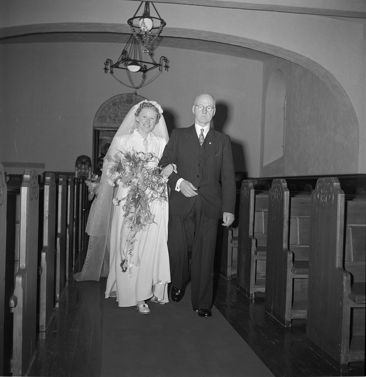 Bryllup i Rjukan kirke mellom Hans Mæland og Borghild Roland. Bruden er på vei opp til alteret sammen med sin far.