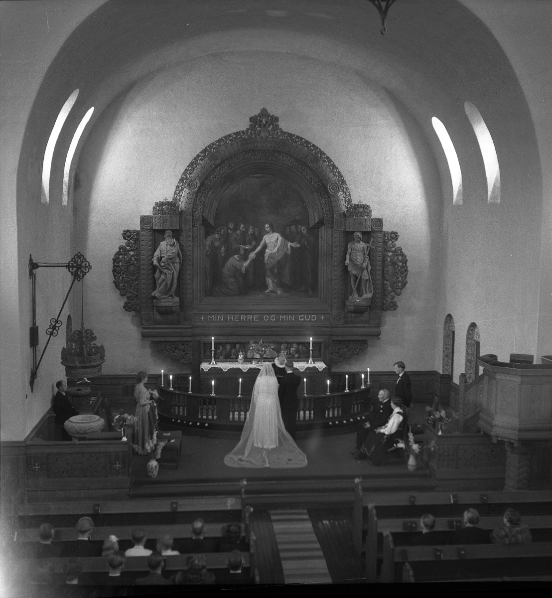 Bryllup i Rjukan kirke for Astri Dahlin og Kjell Moum. Brudeparet står foran alterringen med presten foran seg.