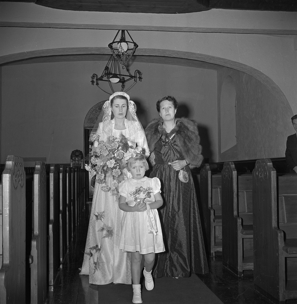 Bryllup i Rjukan kirke for ekteparet Jansen. Bruden på vei ned midtgangen sammen med mor og brudepike.