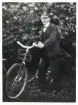 Fjärdingsman Karl Gustaf Johannesson i Aneboda, ca 1925-30, poserar med en cykel i en trädgård.
Något suddigt foto.