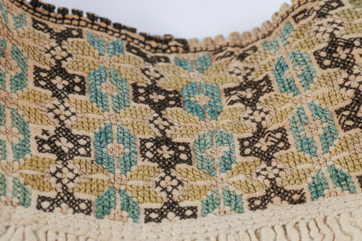 Hvit mannsskjorte med flerfarget broderi som dekor på krave og lengs halssplitt.