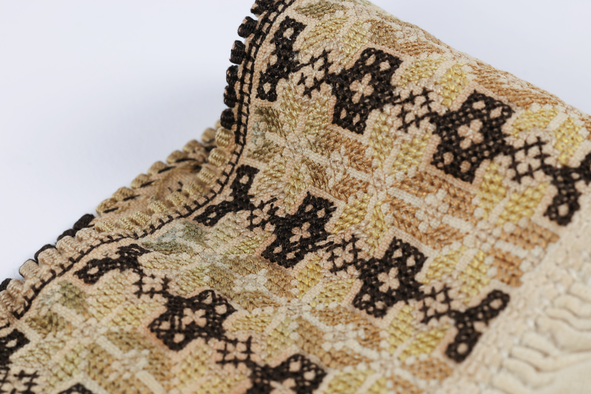 Hvit mannsskjorte med flerfarget broderi som dekor på krave og lengs halssplitt.