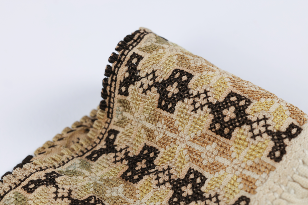 Hvit mannsskjorte med flerfarget broderi som dekor på krave og lengs halssplitt.