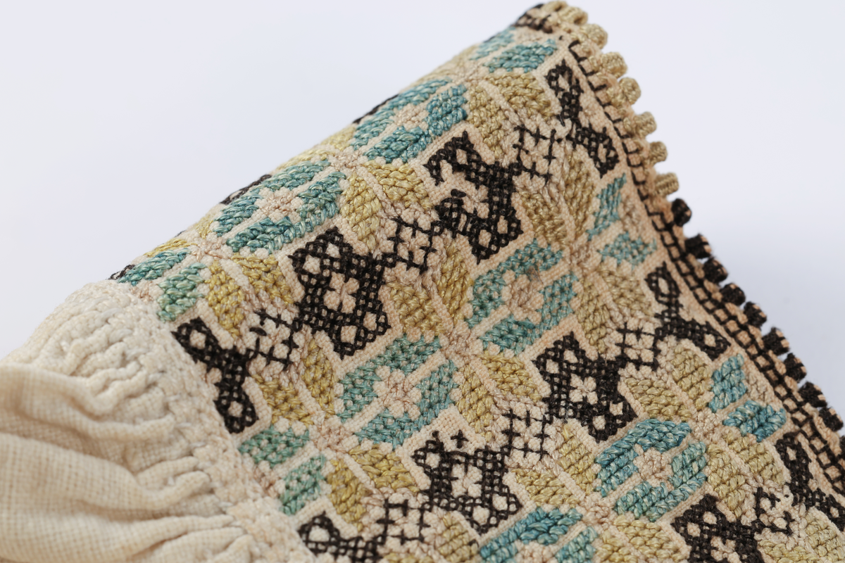 Hvit mannsskjorte med flerfarget broderi som dekor på krave og lengs halssplitt.