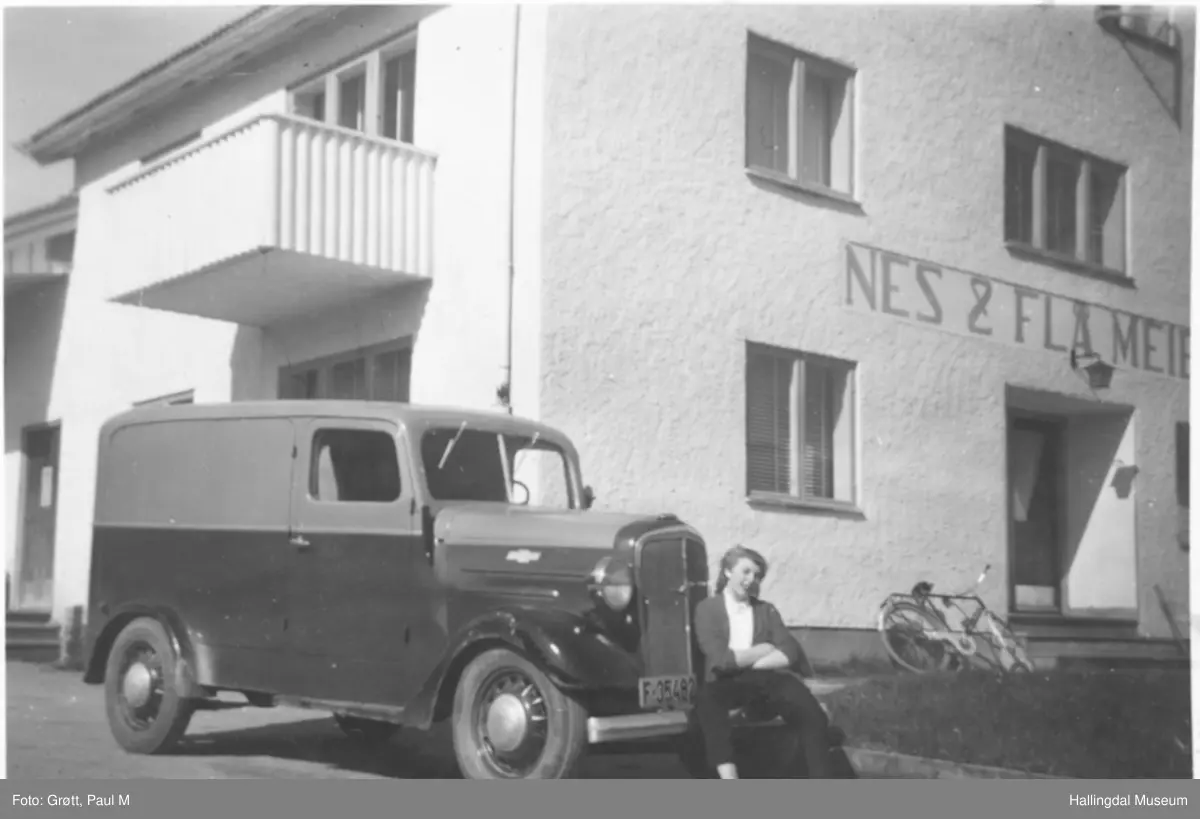 Margit Gjerden-Grøtt sitter på bilen, en Chevrolet Sedan Delivery 1945 modell med 6-sylindret rekke-motor, 3,4 l, 3-trinns gear-kasse. Denne har norskbygd varebilkarosseri bygd på lett lastebil understell med ditto snute. På amerikansk ville den blitt kalt Panel Delivery. Årsmodellen er 1945. Informant er Iver Erlend Stav