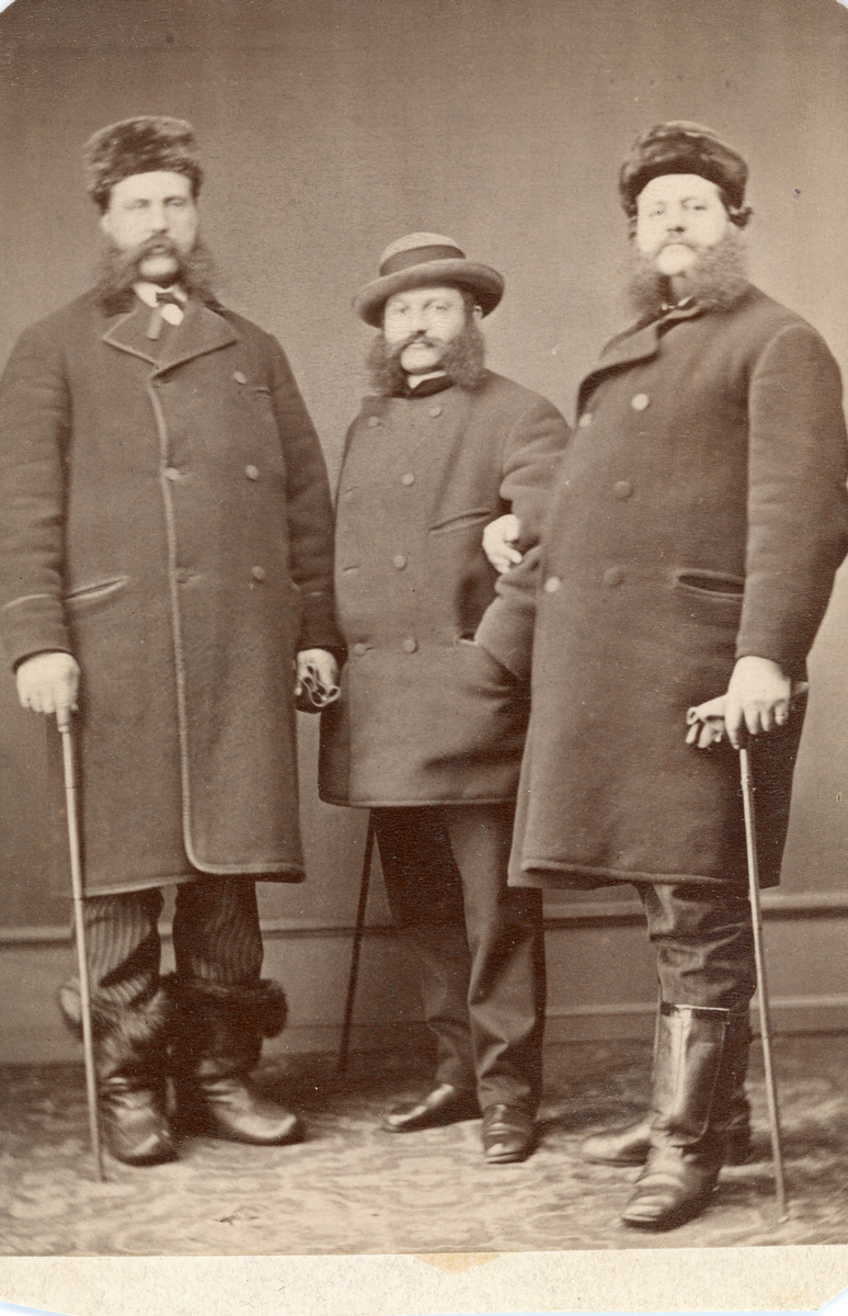Porträtt av tre män varav den mittersta är Gustaf Rettig. Text baksida: "1872 i januari, sen otydlig text, 1 2 3".