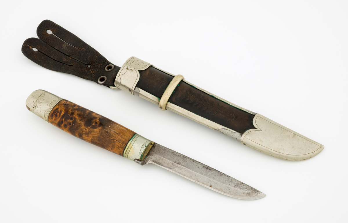 Tollekniv med slire. Knivbladet har stempelet til Alf Bjølseth (1896-1990) fra Malungen i Romedal allmenning, skaftet og slira kan muligens være lagd av Knut Knutsen (1911-1994) fra Ådalsbruk i Løten. Kniven er drøyt 20,4 centimeter lang, målt fra bladspissen til ytterenden av den bakre skaftholken. Bladet utgjør 9,4 centimeter av dette breddemålet. Det har opprinnelig vært 2,2 centimeter bredt ved brystningen, men er nedslipt, slik at gjenstående bredde (bakerst) er cirka 1,7 centimeter. Bladtjukkelsen er 3,7 millimeter bakerst, 2,9 millimeter fremst (umiddelbart bak slipefasene). Bladryggen er en aning konveks i lengderetningen, og den er avfaset mot sidene. Smeden har plassert navnestempelet sitt oppunder bladryggen, bakerst på venstre side. 

Skaftet er lagd av brunbeiset, noe flammet virke, men forsterket med holker, antakelig av nysølv, i begge ender. Treskaftet har ovalt tverrsnitt og er noe konvekst i lengderetningen. På midten er tverrsnittet 2,6 X 1,8 centimeter. Den bakre skaftholken er om lag 2,8 centimeter lang og dekorert med to striper med skravurgraverte sirkelsegmenter. I den ytre enden av holken er det innsatt to kiler av et annet metall, antakelig messing. Den bakre enden av tangen, forlengelsen av knivbladet som er tappet gjennom den sentrale delen av knivskaftet, er stuket mot holken. Den fremre holken på skaftet er om lag 1,7 centimeter lang og har enkelt skravert gravyr. 

Slira er lagd av mørkebrunt lær, innsluttet i ei ramme av nysølv. Lengden fra ytterenden av doppskoen til overenden av munningsholken er 17,1 centimeter. Tverrmålet ved sliremunningen - der vidden er størst - er 3,1 X 3,3 centimeter. Lærhylsteret er sammenføyd med en søm i lengdretningen, plassert på baksida av slira. Det nevnte rammeverket består av doppsko og munningsholk, som er forbundet ved hjelp av to sideskinner. Utenpå sideskinnene er det tredd et snaut 6 millimeter bredt slireband, omtrent der hvor skaftet ender når kniven stikkes ned i slira. Nysølvkomponentene i slireramma ser ut til å være tappet sammen. Doppskoen er asymmetrisk, formet slik at det er tydelig hvilken veg bladet skal vendes i slira. Denne komponenten har inngraverte kantlinjer. Munningsholken har rett overkant, men et oppovervendt innsnitt på den delen av undersida som vender fram når kniven bæres i beltet. Også her er det kantlinjer, og linja langs overkanten er supplert med små buer/sirkelsegmenter på undersida. Læret i «vinduet» mellom doppskoen, sideskinnene og slirebandet er dekorert med ei nedoverpekende pil. På baksida av munningsholken er det montert ei hengsle med en oval ring for opphengsstroppen. I denne er det festet ei tofliket lærhempe med spalteåpninger som gjorde at slira kunne forankres i knapper i bukselinninga til knivbrukeren.