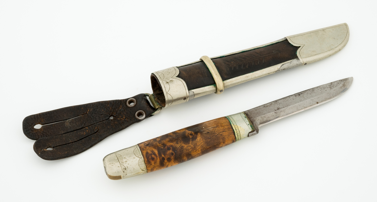 Tollekniv med slire. Knivbladet har stempelet til Alf Bjølseth (1896-1990) fra Malungen i Romedal allmenning, skaftet og slira kan muligens være lagd av Knut Knutsen (1911-1994) fra Ådalsbruk i Løten. Kniven er drøyt 20,4 centimeter lang, målt fra bladspissen til ytterenden av den bakre skaftholken. Bladet utgjør 9,4 centimeter av dette breddemålet. Det har opprinnelig vært 2,2 centimeter bredt ved brystningen, men er nedslipt, slik at gjenstående bredde (bakerst) er cirka 1,7 centimeter. Bladtjukkelsen er 3,7 millimeter bakerst, 2,9 millimeter fremst (umiddelbart bak slipefasene). Bladryggen er en aning konveks i lengderetningen, og den er avfaset mot sidene. Smeden har plassert navnestempelet sitt oppunder bladryggen, bakerst på venstre side. 

Skaftet er lagd av brunbeiset, noe flammet virke, men forsterket med holker, antakelig av nysølv, i begge ender. Treskaftet har ovalt tverrsnitt og er noe konvekst i lengderetningen. På midten er tverrsnittet 2,6 X 1,8 centimeter. Den bakre skaftholken er om lag 2,8 centimeter lang og dekorert med to striper med skravurgraverte sirkelsegmenter. I den ytre enden av holken er det innsatt to kiler av et annet metall, antakelig messing. Den bakre enden av tangen, forlengelsen av knivbladet som er tappet gjennom den sentrale delen av knivskaftet, er stuket mot holken. Den fremre holken på skaftet er om lag 1,7 centimeter lang og har enkelt skravert gravyr. 

Slira er lagd av mørkebrunt lær, innsluttet i ei ramme av nysølv. Lengden fra ytterenden av doppskoen til overenden av munningsholken er 17,1 centimeter. Tverrmålet ved sliremunningen - der vidden er størst - er 3,1 X 3,3 centimeter. Lærhylsteret er sammenføyd med en søm i lengdretningen, plassert på baksida av slira. Det nevnte rammeverket består av doppsko og munningsholk, som er forbundet ved hjelp av to sideskinner. Utenpå sideskinnene er det tredd et snaut 6 millimeter bredt slireband, omtrent der hvor skaftet ender når kniven stikkes ned i slira. Nysølvkomponentene i slireramma ser ut til å være tappet sammen. Doppskoen er asymmetrisk, formet slik at det er tydelig hvilken veg bladet skal vendes i slira. Denne komponenten har inngraverte kantlinjer. Munningsholken har rett overkant, men et oppovervendt innsnitt på den delen av undersida som vender fram når kniven bæres i beltet. Også her er det kantlinjer, og linja langs overkanten er supplert med små buer/sirkelsegmenter på undersida. Læret i «vinduet» mellom doppskoen, sideskinnene og slirebandet er dekorert med ei nedoverpekende pil. På baksida av munningsholken er det montert ei hengsle med en oval ring for opphengsstroppen. I denne er det festet ei tofliket lærhempe med spalteåpninger som gjorde at slira kunne forankres i knapper i bukselinninga til knivbrukeren.