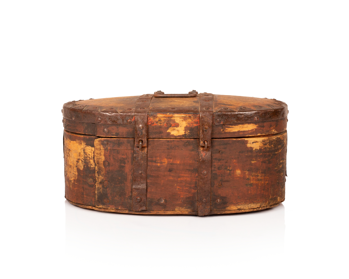 Brun bomme med lås og nøkkel. Den er ovalformet med et svakt hvelvet lokk som er festet med hengsler. Bunnen av bommen er plan. Videre er både bunnen av bommen og toppen av lokket laget av gran, mens sidene er laget av bjørk. 

Lokket og bommens sider er sveipet og består av tynne bjørkelapper, i relativ kraftige dimensjoner, som er brettet sammen for å danne bommens form. Bjørkelappen overlapper hverandre med en god del cm på baksiden og er festet med dobbel nagling. Det er fire nagler i hver av de to rekkene som fester siden sammen. De to rekkene står parallelle overfor hverandre med ca. 5 cm mellomrom. Siden til lokket er festet med en nagle i hver rekke, og i tillegg er det satt inn en nagle nederst på bommen mellom de to rekkene samt en i lokket. 

To smidde jernbånd går fra fremsiden av bommen over lokket og ned på baksiden. På baksiden er det satt inn løkkehengsler i jernbåndene til lokket. Båndene er satt på plass med jernnagler. Rundt toppen av lokket er det et jernbånd som fester lokkets topp og side sammen. Båndet er bøyd over siden, festet med nagler og dekorerte med innovervendte tagger. Midt på bommens lokk er det et håndtak som er festet med nagler. Det er i tillegg jernbånd som går ned på hver side av bommen, disse strekker seg ikke over lokket. 

Bommen har en smidd lås med et hjerteformet nøkkelskilt, og en tilhørende nøkkel. Man kan se rester av brun oljemaling på utsiden av bommen. 