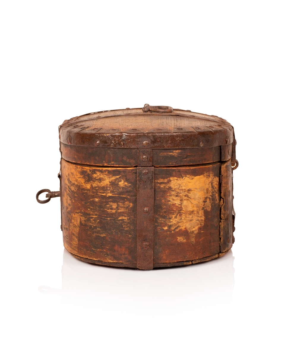 Brun bomme med lås og nøkkel. Den er ovalformet med et svakt hvelvet lokk som er festet med hengsler. Bunnen av bommen er plan. Videre er både bunnen av bommen og toppen av lokket laget av gran, mens sidene er laget av bjørk. 

Lokket og bommens sider er sveipet og består av tynne bjørkelapper, i relativ kraftige dimensjoner, som er brettet sammen for å danne bommens form. Bjørkelappen overlapper hverandre med en god del cm på baksiden og er festet med dobbel nagling. Det er fire nagler i hver av de to rekkene som fester siden sammen. De to rekkene står parallelle overfor hverandre med ca. 5 cm mellomrom. Siden til lokket er festet med en nagle i hver rekke, og i tillegg er det satt inn en nagle nederst på bommen mellom de to rekkene samt en i lokket. 

To smidde jernbånd går fra fremsiden av bommen over lokket og ned på baksiden. På baksiden er det satt inn løkkehengsler i jernbåndene til lokket. Båndene er satt på plass med jernnagler. Rundt toppen av lokket er det et jernbånd som fester lokkets topp og side sammen. Båndet er bøyd over siden, festet med nagler og dekorerte med innovervendte tagger. Midt på bommens lokk er det et håndtak som er festet med nagler. Det er i tillegg jernbånd som går ned på hver side av bommen, disse strekker seg ikke over lokket. 

Bommen har en smidd lås med et hjerteformet nøkkelskilt, og en tilhørende nøkkel. Man kan se rester av brun oljemaling på utsiden av bommen. 