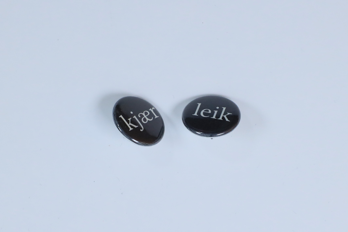 To øyredobbar (utgjer eitt par) med påskrifta "kjær" og "leik"