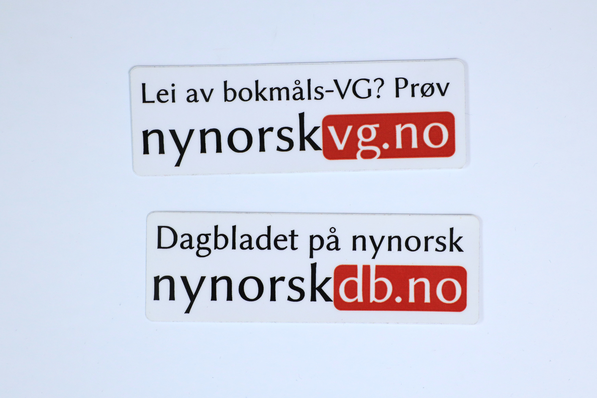 To klistremerke frå Norsk Målungdom si samling, med påskrifta "Lei av bokmåls-VG? Prøv nynorskvg.no" og "Dagbladet på nynorsk. nynorskdb.no"