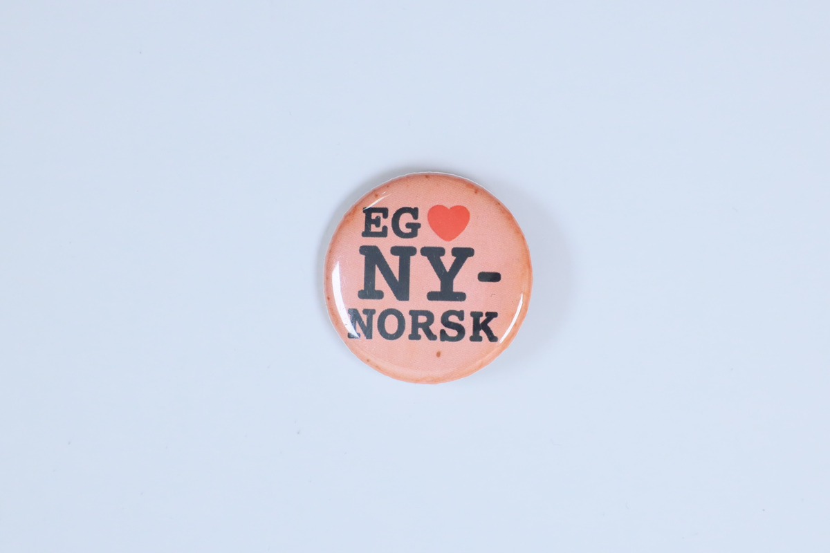 Jakkemerke frå Norsk Målungdom si samling, med påskrifta "Eg [hjarte] nynorsk"