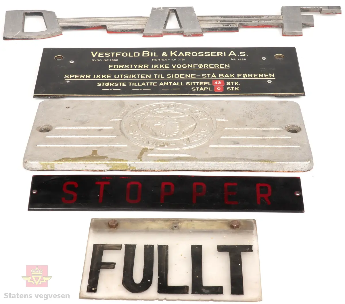 Metall-emblemer og skilt som har vært montert på forskjellige typer busser. Skiltene kommer fra blant annet kjøretøy som Scania, DAF, VOLVO, Daimler-Benz og General motors, og endel skilter fra Norske karosserifabrikker som for eksempel Vestfold Bil & Karosseri, Larvik Karosseri og T. Knudsen karosserifabrikk.