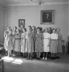 Blindskolan, 1943. 
En damkör sjunger i en sal. På väggen syns porträtt av bl.a. biskop Johan Andersson, Växjö.