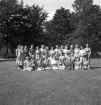Blindskolan, 1943. 
Ett antal damer har ställt upp för fotografering på en gräsmatta utanför Blindskolan.