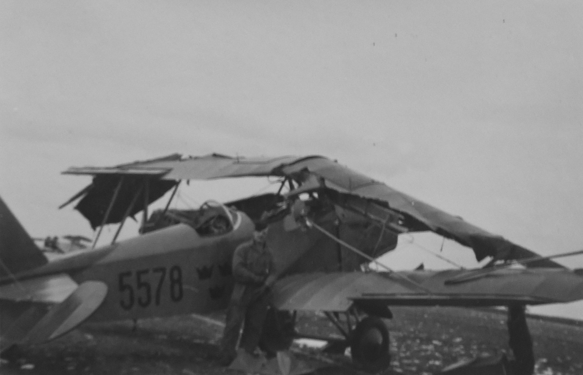 Skadat flygplan Sk 6 nummer 5578 står på flygfältet på F 5 Ljungbyhed, efter kollision den 4 mars 1935. En flygtekniker står vid flygplanet.

Text vid foto: "Hur ett flygplan ser ut när man har försökt landa på det."