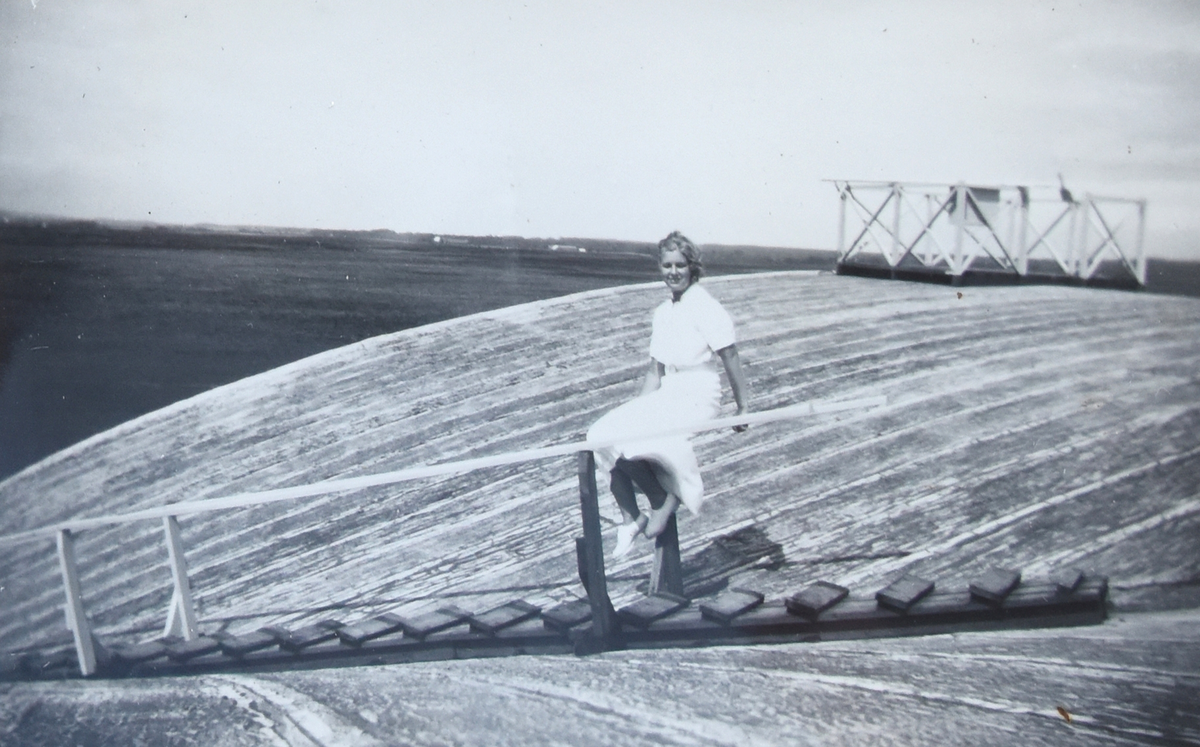 En kvinna sitter på taket på en flyghangar på F 5 Krigsflygskolan i Ljungbyhed, omkring 1935-1937.

Text vid foto: "Gullan på hangartaket, F5"