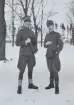 Porträttfoto i helbild av två militärer ur Flygvapnet, poserandes utomhus vintertid, omkring 1935.

Text vid foto: 