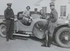 En grupp människor vid en bil framför ett hus, omkring 1935-1937. Två militärer, två civilklädda män och en kvinna.

Text vid foto: 