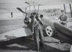 Militäre flygaren Nils Olof Sefeldt (Svensson) vid flygplan Sk 11 märkt F 5 - 20 inför flygning den 24 augusti 1936. En flygtekniker i arbete med flygplanet.

Text vid foto: 