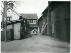 Västerås, Centrum, kv. Linnéa.
Kvinna stående på innergård, 1902.