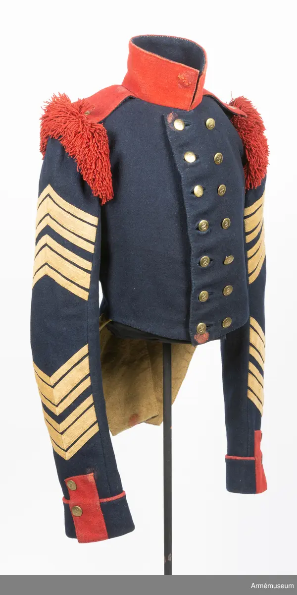 Mörkblå frack med röd krage, mässingsknappar, röda axelprydnader samt ärmdekorationer av gula redgarnsband.

Fracken är sydd av mörkblått kläde och är fodrad i bål och skört med gul boj. Ärmarna är fodrade med oblekt linne- eller hampalärft. Den är rakt avskuren fram och har ett tudelat skört bak, och är konstruerad med fram och sidstycken i ett samt helt bakstycke. Ärmarna är formade tvåsömsärmar med fasta ärmuppslag med röd passpoal, röd matta, och ärmsprund med tre knappar.
Ståndkragen är hög och rakskuren, sydd av rött kläde med foder av blått kläde. De röda axelklaffarna är fastsydda i kragsömmen innerst på axeln, och nedfästa med en knapp ytterst. Framärmarna är dekorerade med gula redgarnsband i två olika bredder, fastsydda i vinklar. På axlarna sitter axelprydnader av röda redgarnsfransar sydda längs med övre delen av ärmsömmen.
Fracken är dubbelknäppt med 7 x 2 knappar och passpoalerade knapphål. Knapparna är av mässing, svagt välvda och dekorerade med siffran 8.
Frackskörtens uppvik är av gult kläde. Sidsömmarnas kurva bak pryds av gula redgarnsband, och vid ryggslutet sitter två knappar.
I nacken sitter en modelletikett av papper fastatt med en grov tråd av jute eller liknande. Plagget är dessutom märkt med ett flertal röda vaxsigill i dåligt skick.
Etiketten har följande text på framsidan:
"Af Kongl Majt Nådigast (...) Modell å Jacka för Westgötha (...) undantag af Westerbottens Reg (...) d. 10 Januari 1829. Axelklaffarne äro genom General (...) d. 17. Januari samma år, fastställ (...).
På Befalnning T. W. Lode (..)
Adjut. Kgl. K (...)"
På baksidan står det:
"Sedan (...)
1845 (?) (...)
fastställt (...)
(...) ställe (...)
(...)" resten oläsligt.