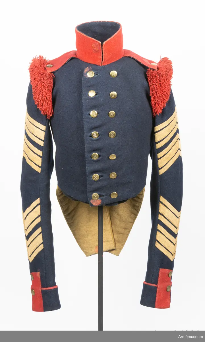 Mörkblå frack med röd krage, mässingsknappar, röda axelprydnader samt ärmdekorationer av gula redgarnsband.

Fracken är sydd av mörkblått kläde och är fodrad i bål och skört med gul boj. Ärmarna är fodrade med oblekt linne- eller hampalärft. Den är rakt avskuren fram och har ett tudelat skört bak, och är konstruerad med fram och sidstycken i ett samt helt bakstycke. Ärmarna är formade tvåsömsärmar med fasta ärmuppslag med röd passpoal, röd matta, och ärmsprund med tre knappar.
Ståndkragen är hög och rakskuren, sydd av rött kläde med foder av blått kläde. De röda axelklaffarna är fastsydda i kragsömmen innerst på axeln, och nedfästa med en knapp ytterst. Framärmarna är dekorerade med gula redgarnsband i två olika bredder, fastsydda i vinklar. På axlarna sitter axelprydnader av röda redgarnsfransar sydda längs med övre delen av ärmsömmen.
Fracken är dubbelknäppt med 7 x 2 knappar och passpoalerade knapphål. Knapparna är av mässing, svagt välvda och dekorerade med siffran 8.
Frackskörtens uppvik är av gult kläde. Sidsömmarnas kurva bak pryds av gula redgarnsband, och vid ryggslutet sitter två knappar.
I nacken sitter en modelletikett av papper fastatt med en grov tråd av jute eller liknande. Plagget är dessutom märkt med ett flertal röda vaxsigill i dåligt skick.
Etiketten har följande text på framsidan:
"Af Kongl Majt Nådigast (...) Modell å Jacka för Westgötha (...) undantag af Westerbottens Reg (...) d. 10 Januari 1829. Axelklaffarne äro genom General (...) d. 17. Januari samma år, fastställ (...).
På Befalnning T. W. Lode (..)
Adjut. Kgl. K (...)"
På baksidan står det:
"Sedan (...)
1845 (?) (...)
fastställt (...)
(...) ställe (...)
(...)" resten oläsligt.