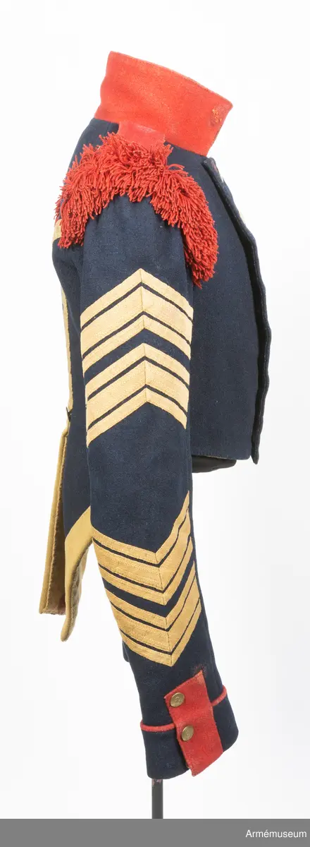 Mörkblå frack med röd krage, mässingsknappar, röda axelprydnader samt ärmdekorationer av gula redgarnsband.

Fracken är sydd av mörkblått kläde och är fodrad i bål och skört med gul boj. Ärmarna är fodrade med oblekt linne- eller hampalärft. Den är rakt avskuren fram och har ett tudelat skört bak, och är konstruerad med fram och sidstycken i ett samt helt bakstycke. Ärmarna är formade tvåsömsärmar med fasta ärmuppslag med röd passpoal, röd matta, och ärmsprund med tre knappar.
Ståndkragen är hög och rakskuren, sydd av rött kläde med foder av blått kläde. De röda axelklaffarna är fastsydda i kragsömmen innerst på axeln, och nedfästa med en knapp ytterst. Framärmarna är dekorerade med gula redgarnsband i två olika bredder, fastsydda i vinklar. På axlarna sitter axelprydnader av röda redgarnsfransar sydda längs med övre delen av ärmsömmen.
Fracken är dubbelknäppt med 7 x 2 knappar och passpoalerade knapphål. Knapparna är av mässing, svagt välvda och dekorerade med siffran 8.
Frackskörtens uppvik är av gult kläde. Sidsömmarnas kurva bak pryds av gula redgarnsband, och vid ryggslutet sitter två knappar.
I nacken sitter en modelletikett av papper fastatt med en grov tråd av jute eller liknande. Plagget är dessutom märkt med ett flertal röda vaxsigill i dåligt skick.
Etiketten har följande text på framsidan:
"Af Kongl Majt Nådigast (...) Modell å Jacka för Westgötha (...) undantag af Westerbottens Reg (...) d. 10 Januari 1829. Axelklaffarne äro genom General (...) d. 17. Januari samma år, fastställ (...).
På Befalnning T. W. Lode (..)
Adjut. Kgl. K (...)"
På baksidan står det:
"Sedan (...)
1845 (?) (...)
fastställt (...)
(...) ställe (...)
(...)" resten oläsligt.