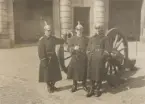 Tre man ur Livregementet till häst K 1 runt kanon vid högvaktsflygeln.