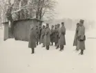 Infanteriskjutskolan Rosersberg  grupp uppställd vid skjul på snöigt fält.