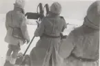 Tre män i vintermundering hanterar dubbel 8 mm luftvärnskulspruta m/1936 på tripodlavett.