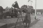 Man med hörlurar och luva hanterar målspaningsaggregat m/1936 Tepaz, vagn med avståndsapparater i bakgrunden.