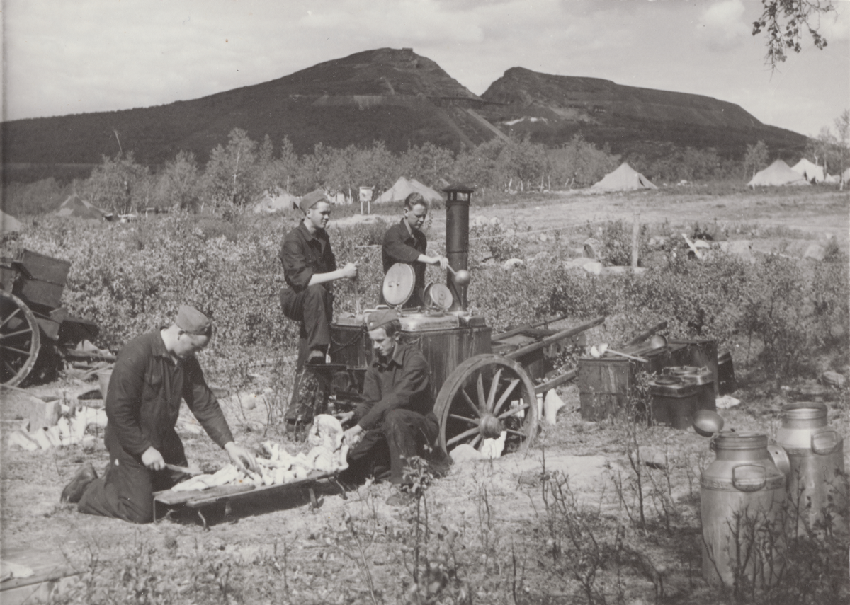 Kockar förbereder mat. Tältläger och Luossavaara i bakgrunden. Foto ur anonym serie från beredskapen i Norrland.