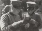 Två män ur FBU studerar anteckningar, iförda uniform m/1910 och skärmmössor, 1930-tal.