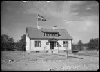 Hus med flagga och trädgård. Fabrikör Nordvall, Kolbäck.
Ur Gustaf Åhmans samling.